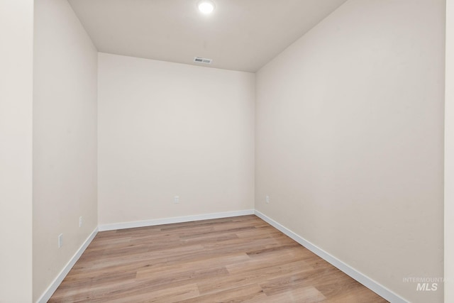 spare room with light wood-type flooring, baseboards, and visible vents