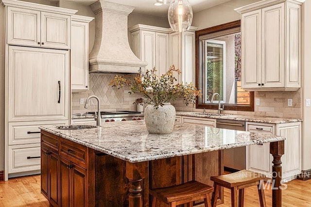 1452 S Hidden Island Pl, Eagle, ID 83616 - kitchen with premium range hood, light stone countertops, backsplash, and light wood-style floors