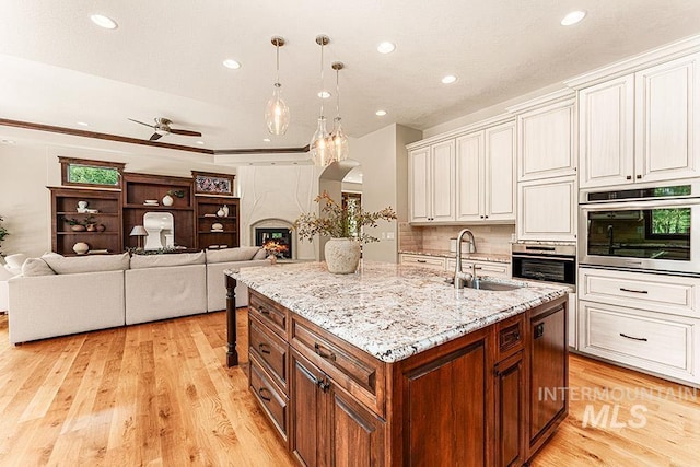 1452 S Hidden Island Pl, Eagle, ID 83616 - kitchen featuring stainless steel oven, recessed lighting, light wood-style floors, a ceiling fan, and arched walkways
