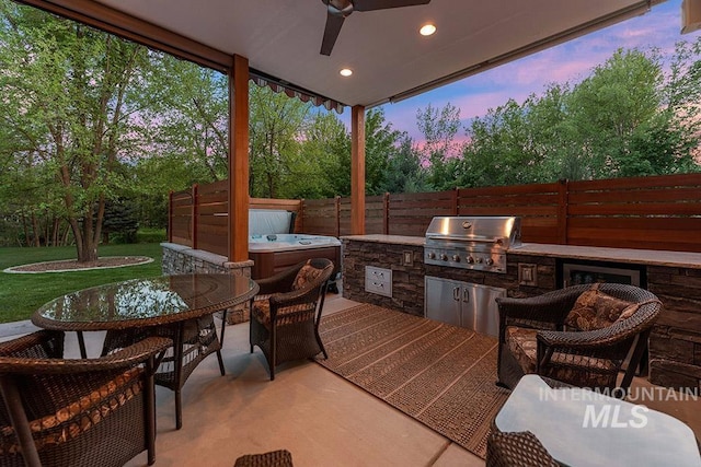 1452 S Hidden Island Pl, Eagle, ID 83616 - patio terrace at dusk with an outdoor kitchen, outdoor dining area, ceiling fan, a patio area, and a hot tub