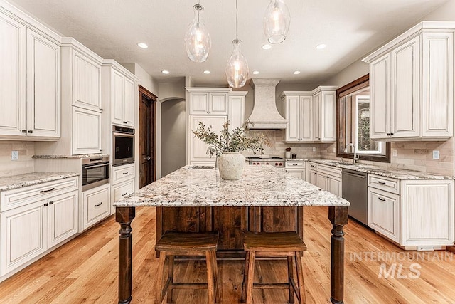 1452 S Hidden Island Pl, Eagle, ID 83616 - kitchen with appliances with stainless steel finishes, premium range hood, a kitchen bar, a center island, and decorative backsplash