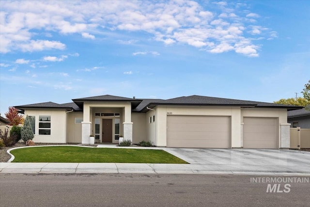 prairie-style home featuring a garage and a front lawn