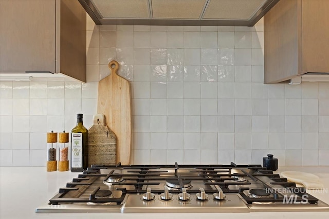 details featuring stainless steel gas stovetop and backsplash