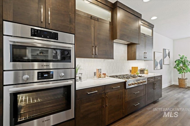 kitchen with tasteful backsplash, appliances with stainless steel finishes, and dark brown cabinets