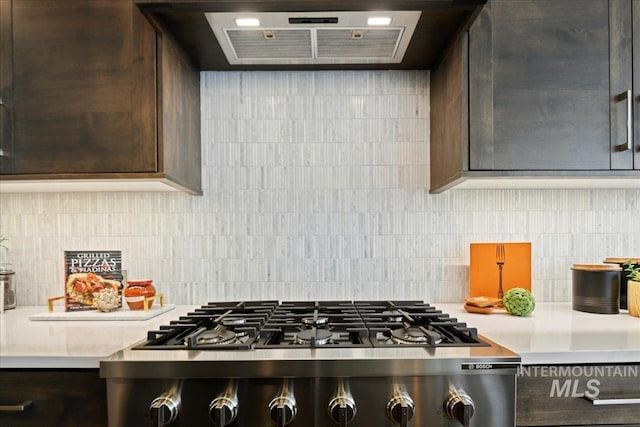 kitchen with tasteful backsplash, dark brown cabinetry, extractor fan, and gas stovetop