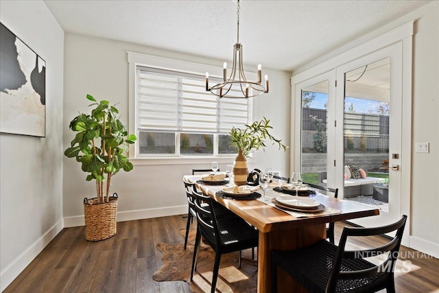 dining area featuring an inviting chandelier, dark hardwood / wood-style floors, and a textured ceiling