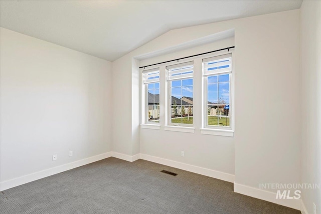 carpeted spare room featuring lofted ceiling