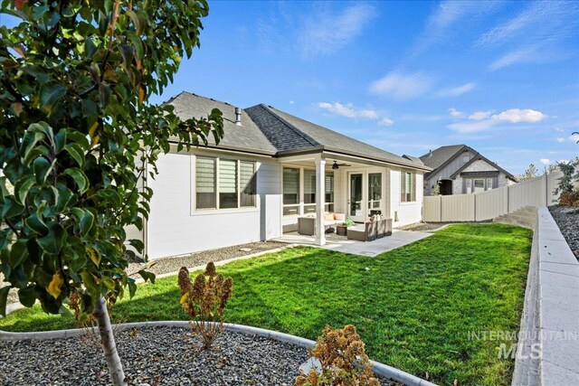 rear view of house featuring a patio area, outdoor lounge area, ceiling fan, and a lawn