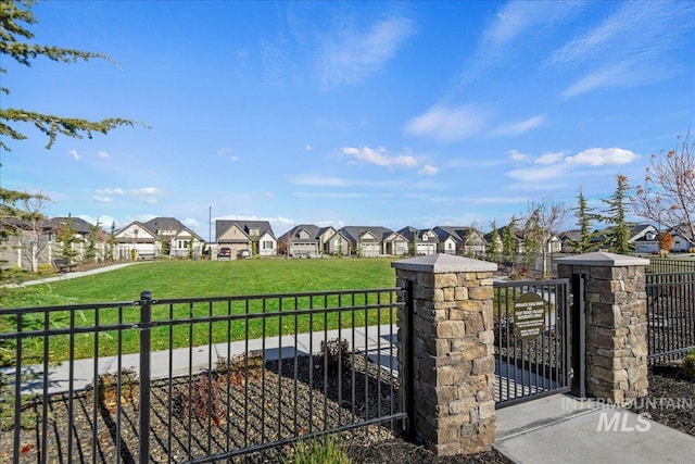 view of gate with a lawn