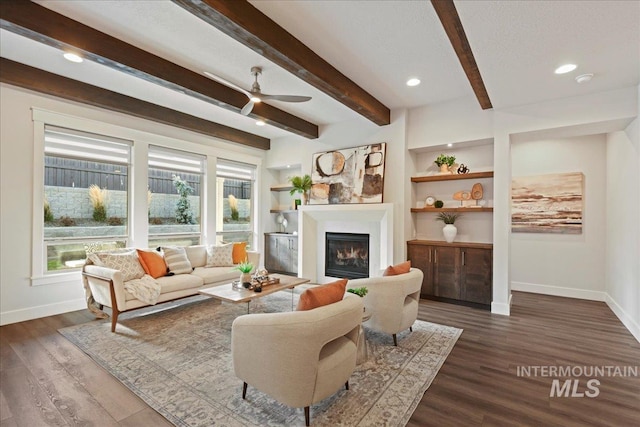 living room with beamed ceiling, a healthy amount of sunlight, and dark wood-type flooring