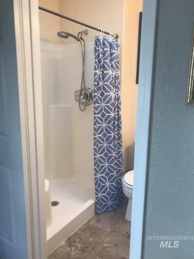 bathroom featuring curtained shower and toilet