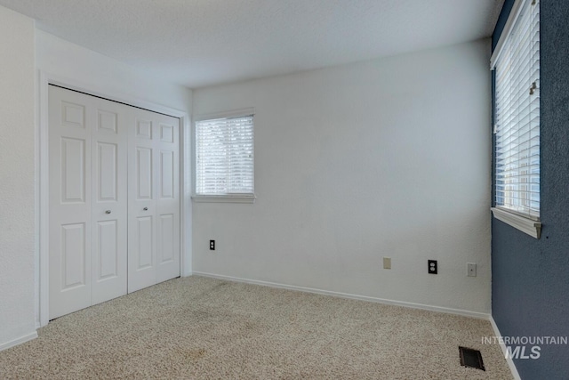 unfurnished bedroom featuring carpet flooring and a closet