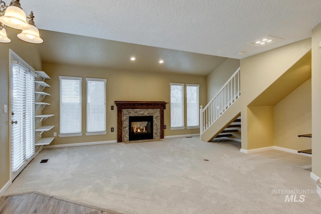 unfurnished living room featuring light carpet, a textured ceiling, and plenty of natural light