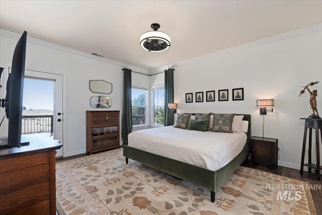 bedroom featuring visible vents, multiple windows, light wood-style flooring, and crown molding