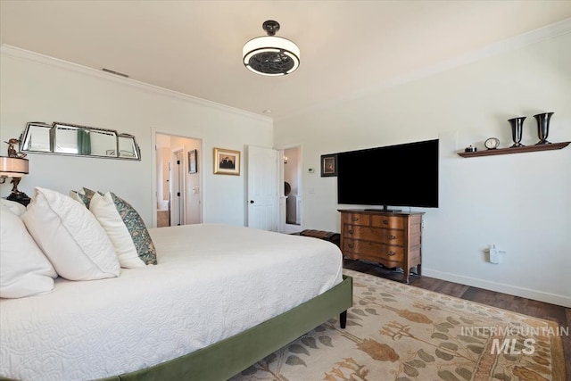 bedroom with visible vents, crown molding, baseboards, and wood finished floors