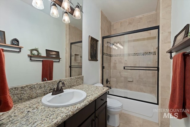 bathroom with vanity, toilet, shower / bath combination with glass door, and tile patterned flooring