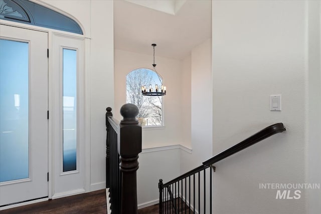 foyer entrance with a notable chandelier and dark wood-style flooring