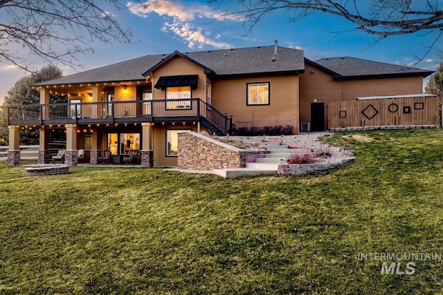 back of property featuring stairway, a lawn, a patio, and a deck