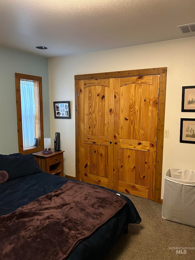 carpeted bedroom with a textured ceiling