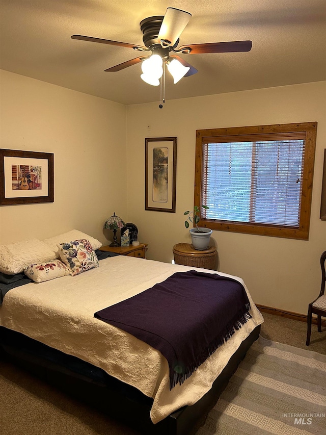 bedroom featuring ceiling fan, carpet floors, and a textured ceiling