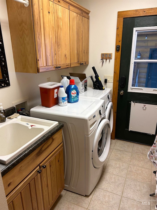 washroom featuring cabinets, separate washer and dryer, sink, and light tile patterned floors