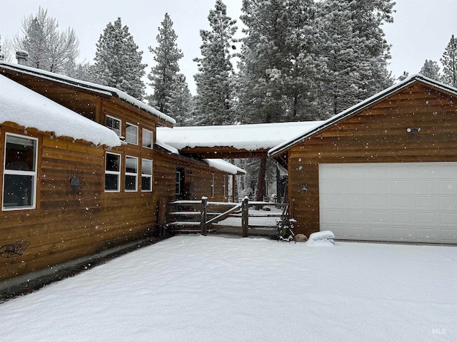 view of snowy exterior with a garage