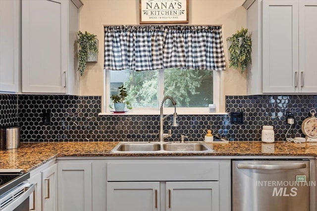 kitchen with sink, white cabinetry, backsplash, and appliances with stainless steel finishes