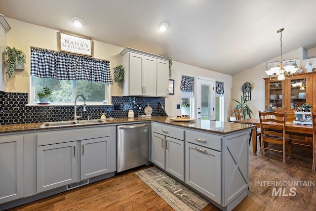 kitchen featuring kitchen peninsula, dishwasher, hanging light fixtures, gray cabinets, and sink