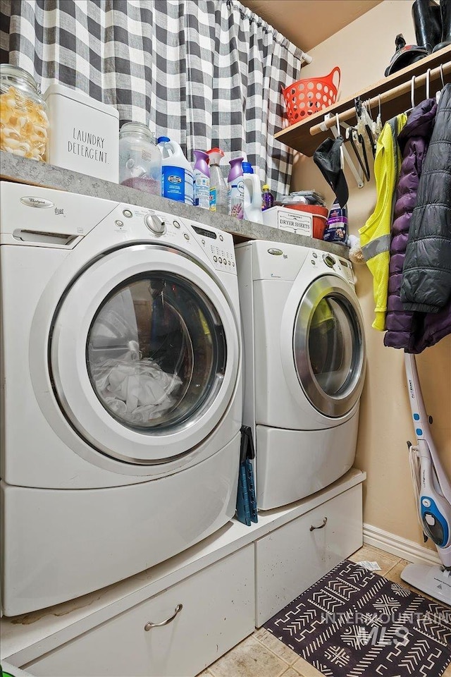 laundry room featuring washing machine and dryer and light tile patterned flooring