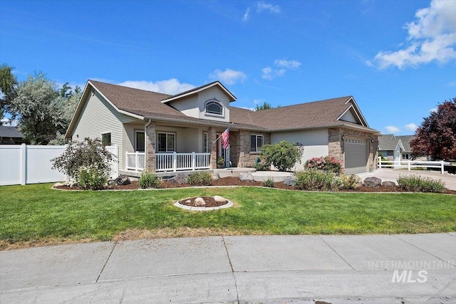 view of front facade with a front yard, covered porch, and a garage