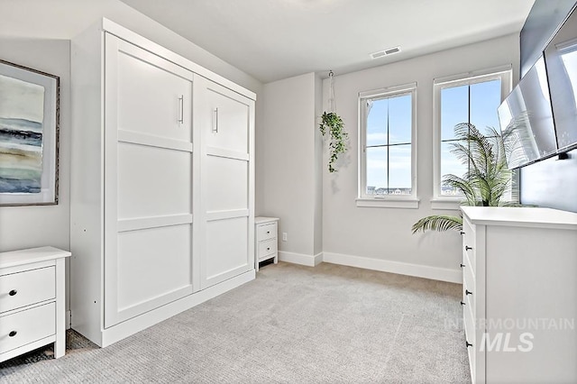 unfurnished room featuring baseboards, light carpet, and visible vents