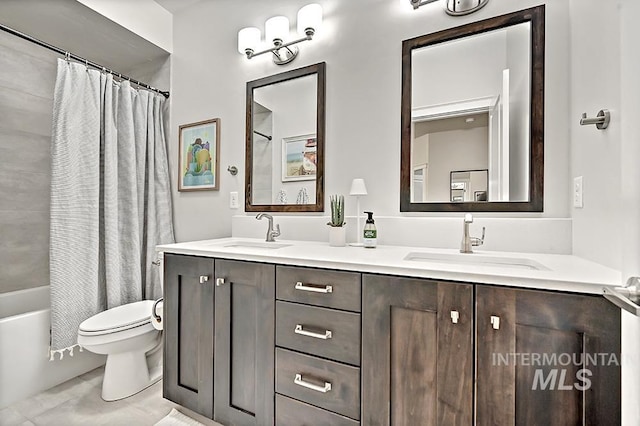 full bathroom featuring double vanity, a sink, and toilet