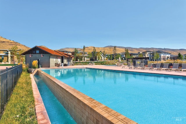 pool featuring a mountain view, a residential view, and fence
