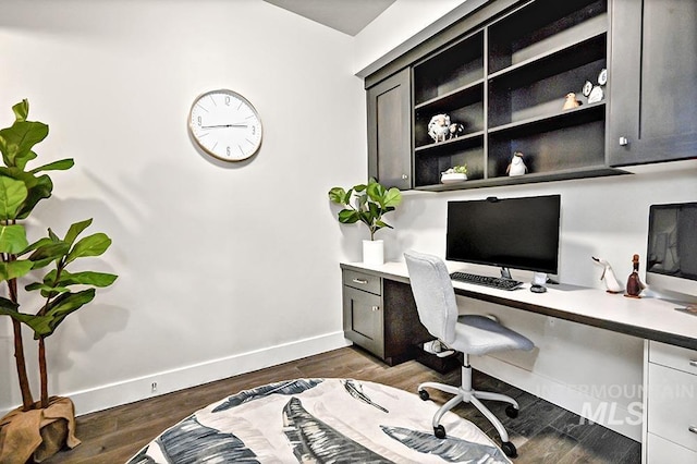office space with baseboards, built in study area, and dark wood-type flooring