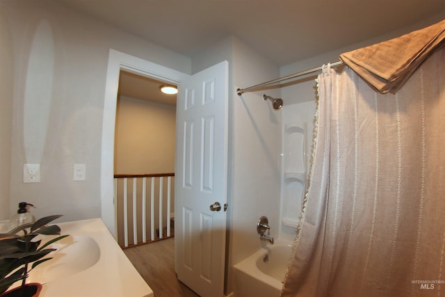 bathroom featuring hardwood / wood-style floors, shower / bathtub combination with curtain, and vanity