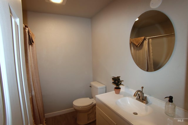 bathroom featuring walk in shower, vanity, toilet, and hardwood / wood-style flooring