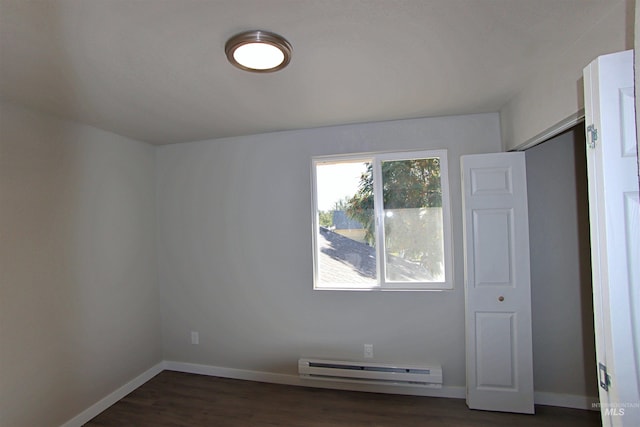 interior space featuring a closet, dark hardwood / wood-style flooring, and a baseboard heating unit