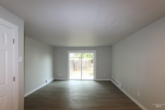 spare room with dark hardwood / wood-style floors and baseboard heating