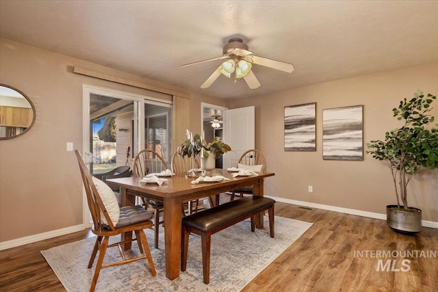 dining room with a textured ceiling, dark hardwood / wood-style flooring, and ceiling fan