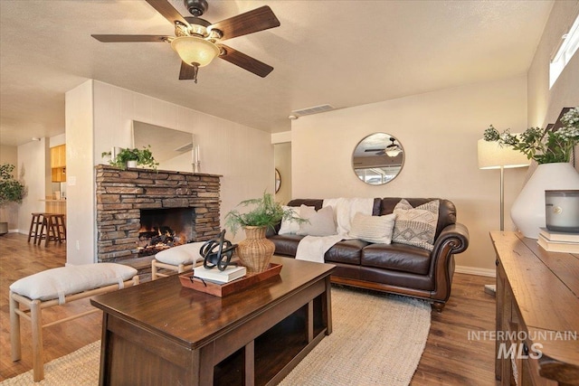 living room with a fireplace, dark wood-type flooring, and a textured ceiling