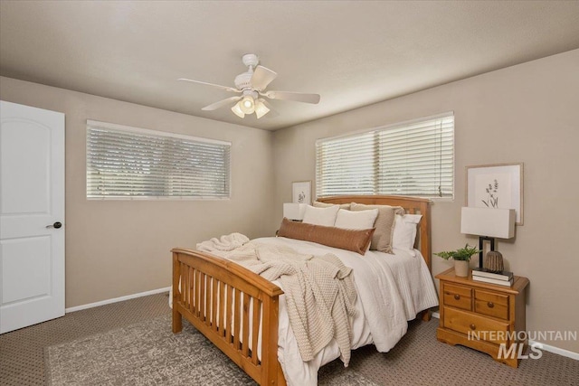 carpeted bedroom featuring multiple windows and ceiling fan