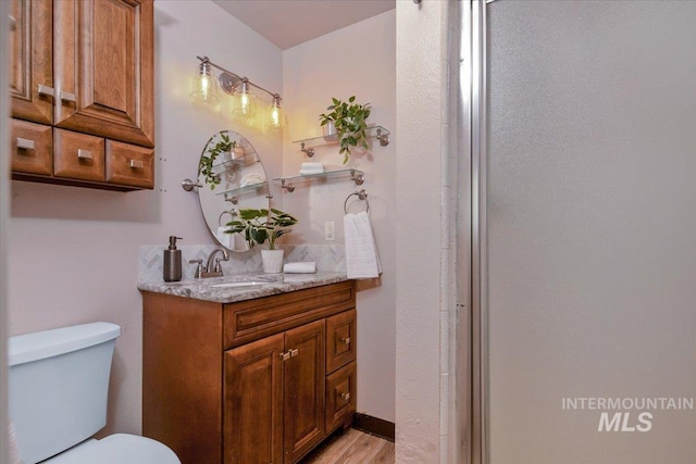 bathroom featuring wood-type flooring, vanity, and toilet