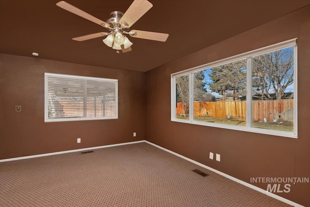 unfurnished room featuring carpet flooring, ceiling fan, and a wealth of natural light