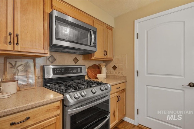 kitchen featuring appliances with stainless steel finishes and tasteful backsplash