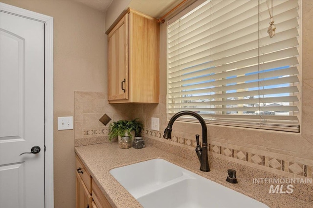 kitchen featuring backsplash, light brown cabinets, and sink