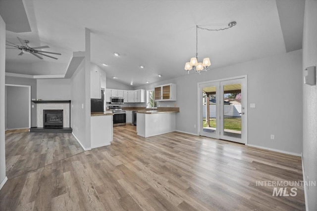 kitchen featuring white cabinets, open floor plan, appliances with stainless steel finishes, light wood-type flooring, and lofted ceiling