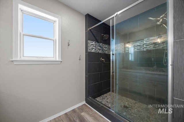 full bathroom featuring a shower stall, wood finished floors, and baseboards