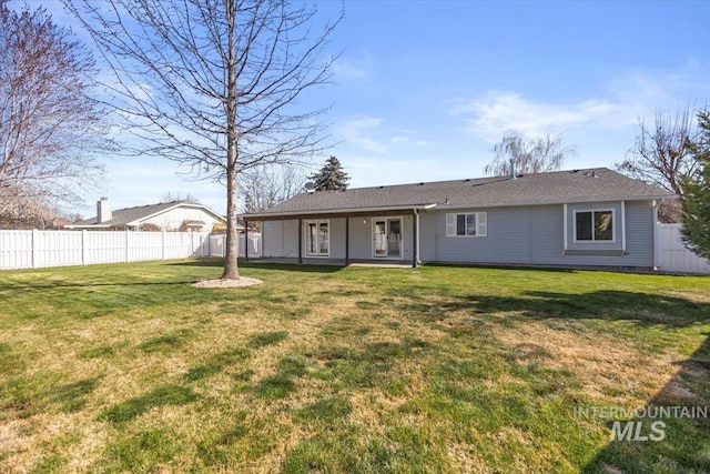 back of house with fence and a lawn