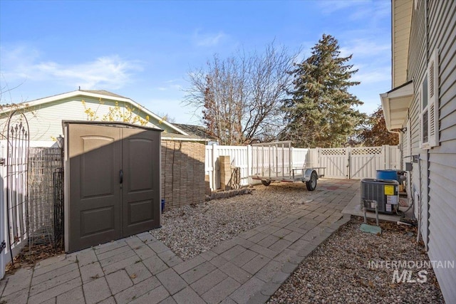 view of patio with a storage shed, a fenced backyard, central AC, and a gate