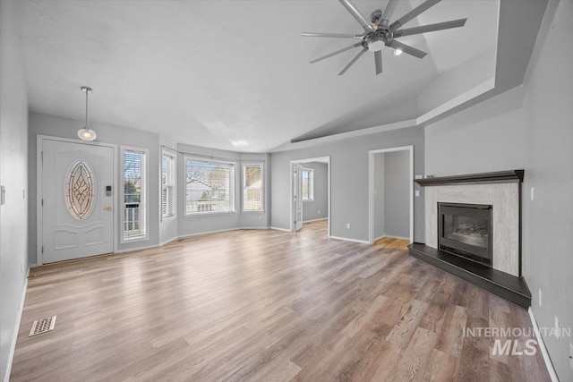 unfurnished living room with a glass covered fireplace, visible vents, a ceiling fan, and wood finished floors